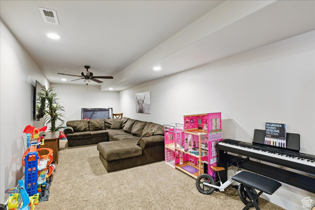 Carpeted living area with recessed lighting and ceiling fan
