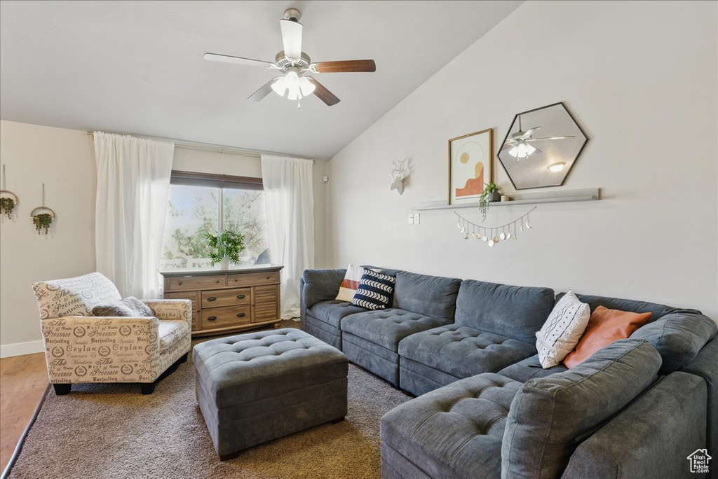 Living room with vaulted ceiling, ceiling fan, and baseboards