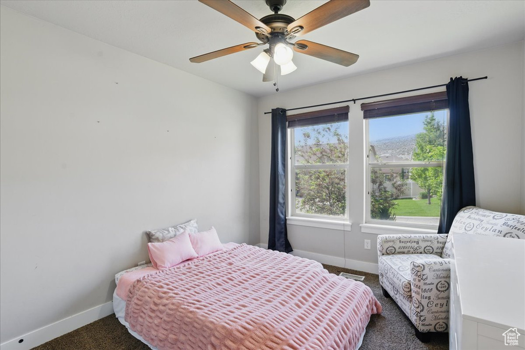 Carpeted bedroom with baseboards and a ceiling fan