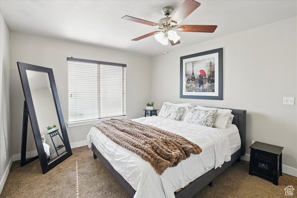 Carpeted bedroom with baseboards and ceiling fan