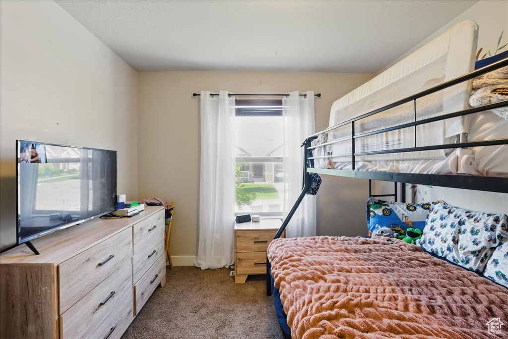 Carpeted bedroom featuring multiple windows