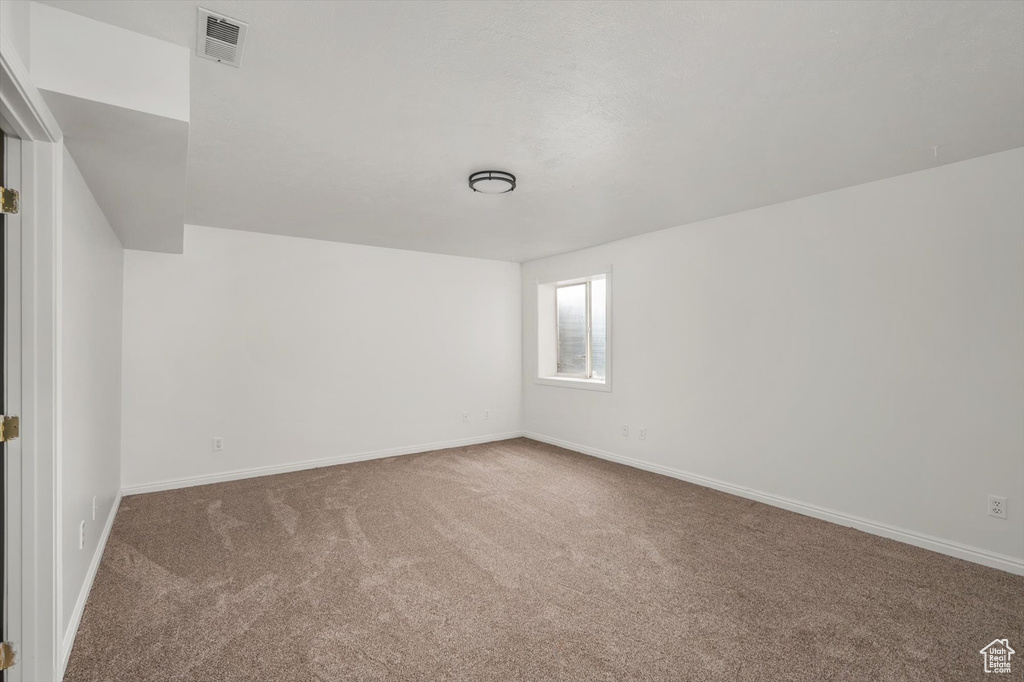 Empty room with carpet floors and baseboards