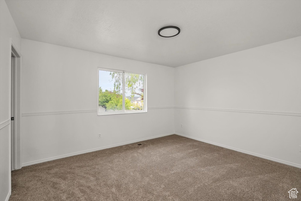 Unfurnished room with carpet floors and baseboards