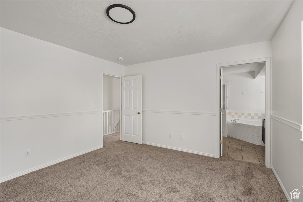 Unfurnished bedroom with carpet, baseboards, and ensuite bath
