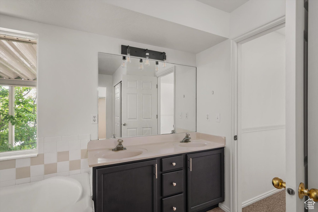 Bathroom with double vanity and a tub to relax in