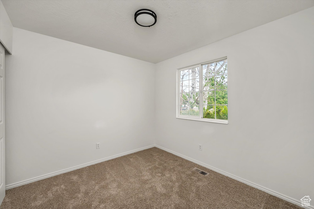 Empty room featuring carpet floors and baseboards