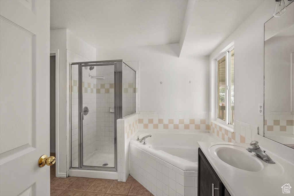 Full bathroom with a garden tub, a shower stall, vanity, and tile patterned flooring