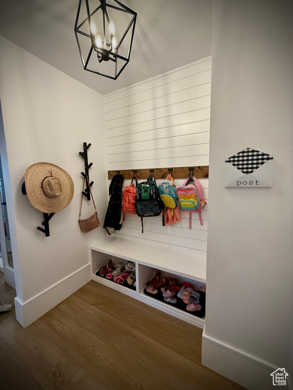 Mudroom featuring wood finished floors, a chandelier, and baseboards