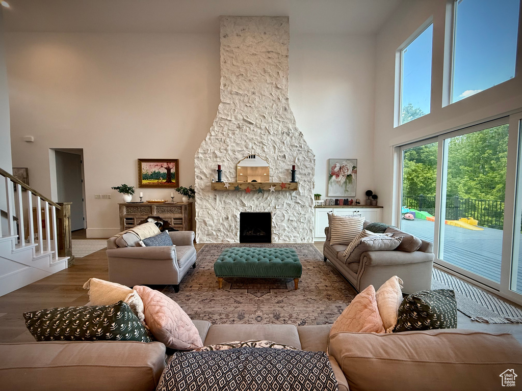 Living area featuring a high ceiling, wood finished floors, plenty of natural light, stairs, and baseboards