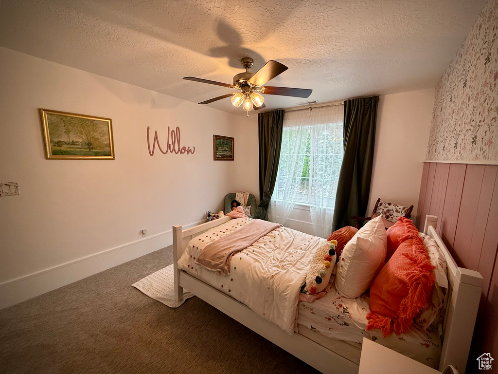 Bedroom featuring carpet flooring, a textured ceiling, and a ceiling fan