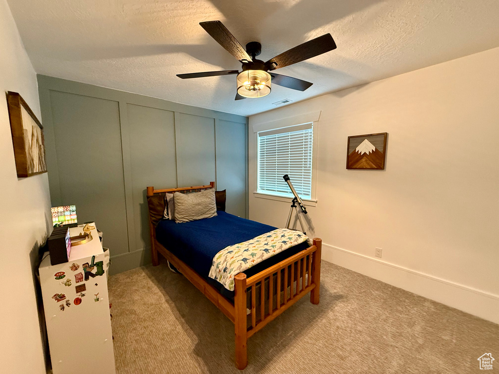 Bedroom featuring carpet, ceiling fan, and a textured ceiling