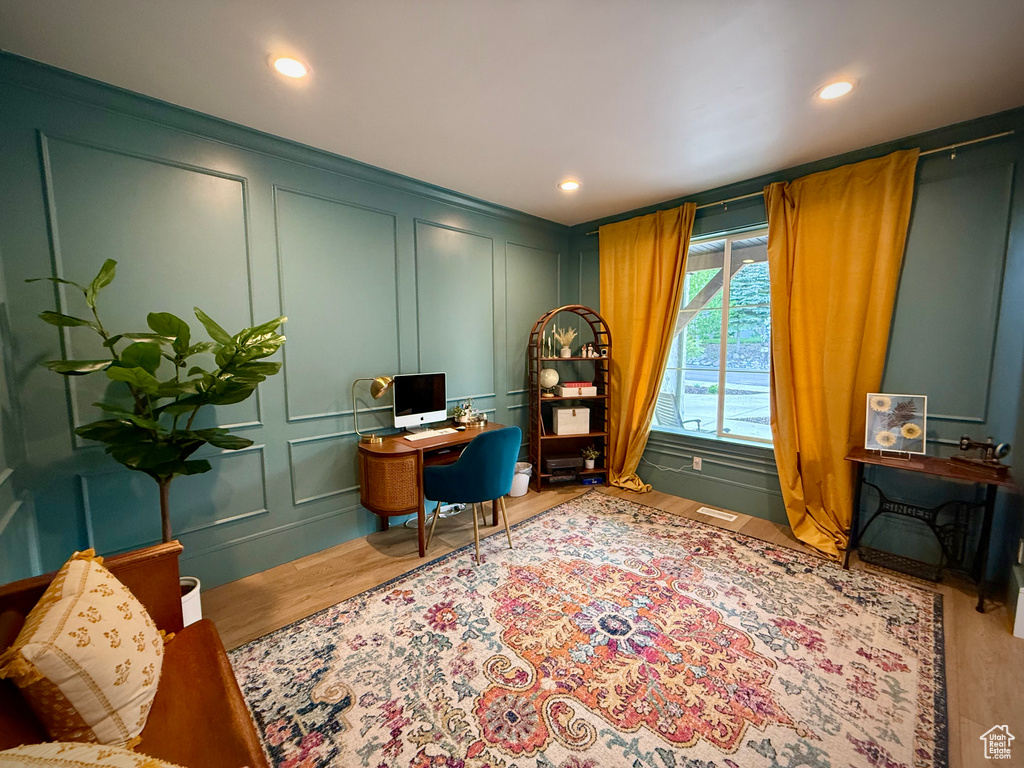 Home office with a decorative wall, wood finished floors, and recessed lighting