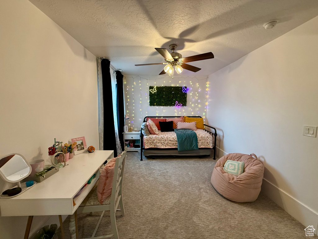 Bedroom featuring carpet, a textured ceiling, and ceiling fan