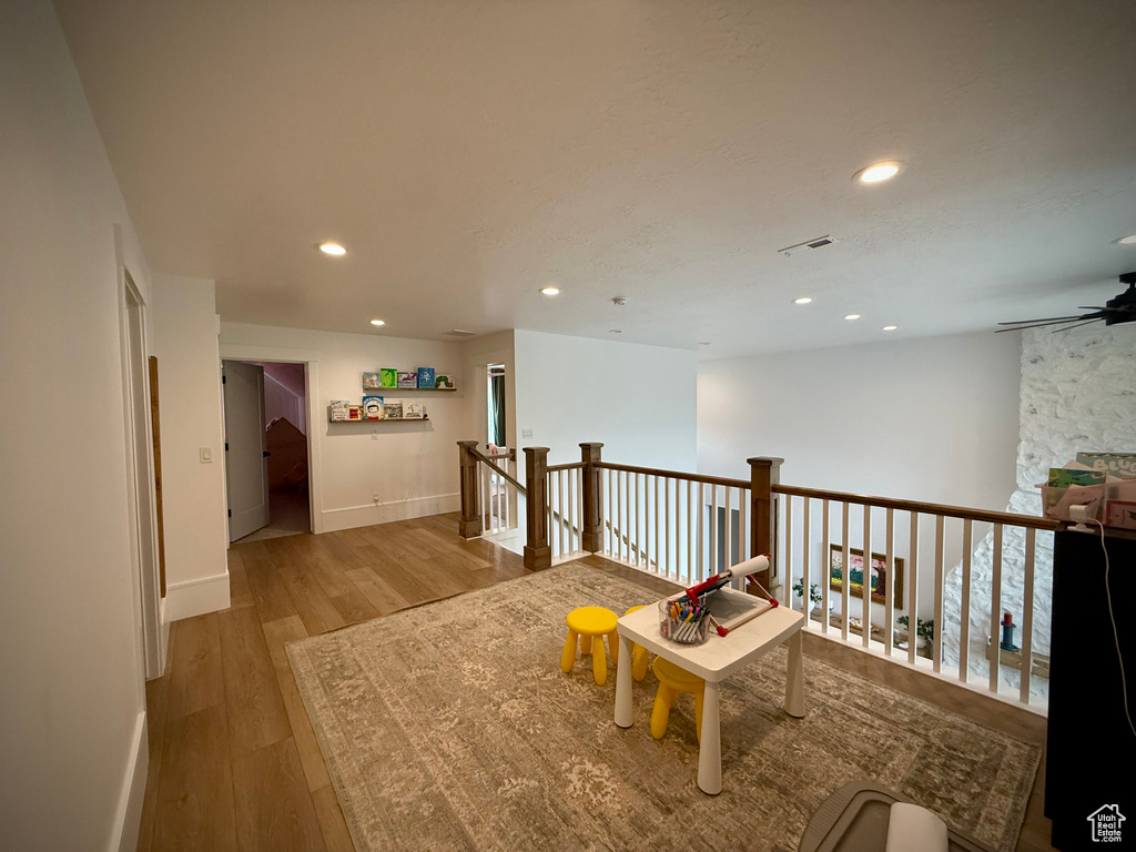 Living area with wood finished floors, recessed lighting, a ceiling fan, an upstairs landing, and baseboards