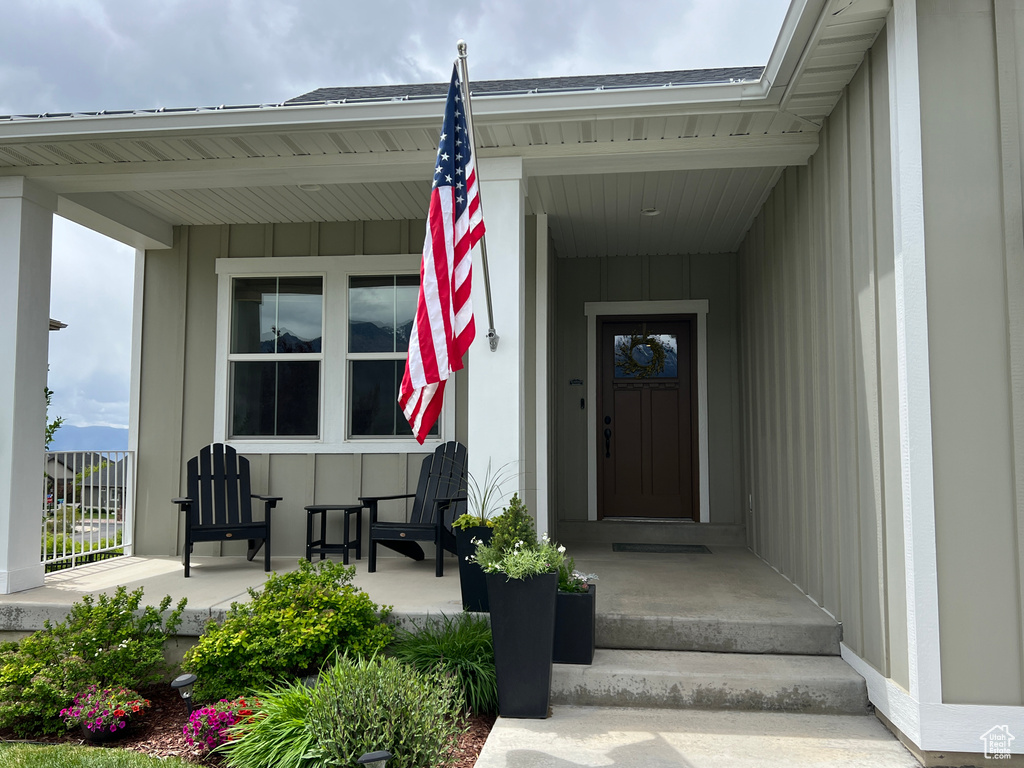 Doorway to property with a porch and board and batten siding
