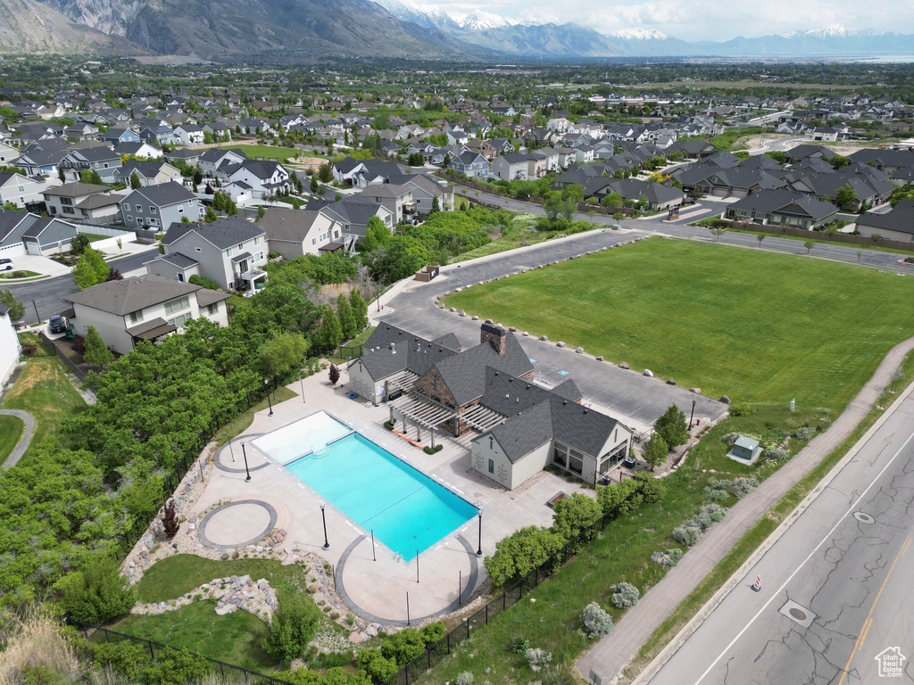 Aerial view of residential area with a pool and a mountainous background