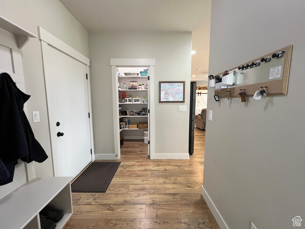 Mudroom with light wood-style flooring and baseboards