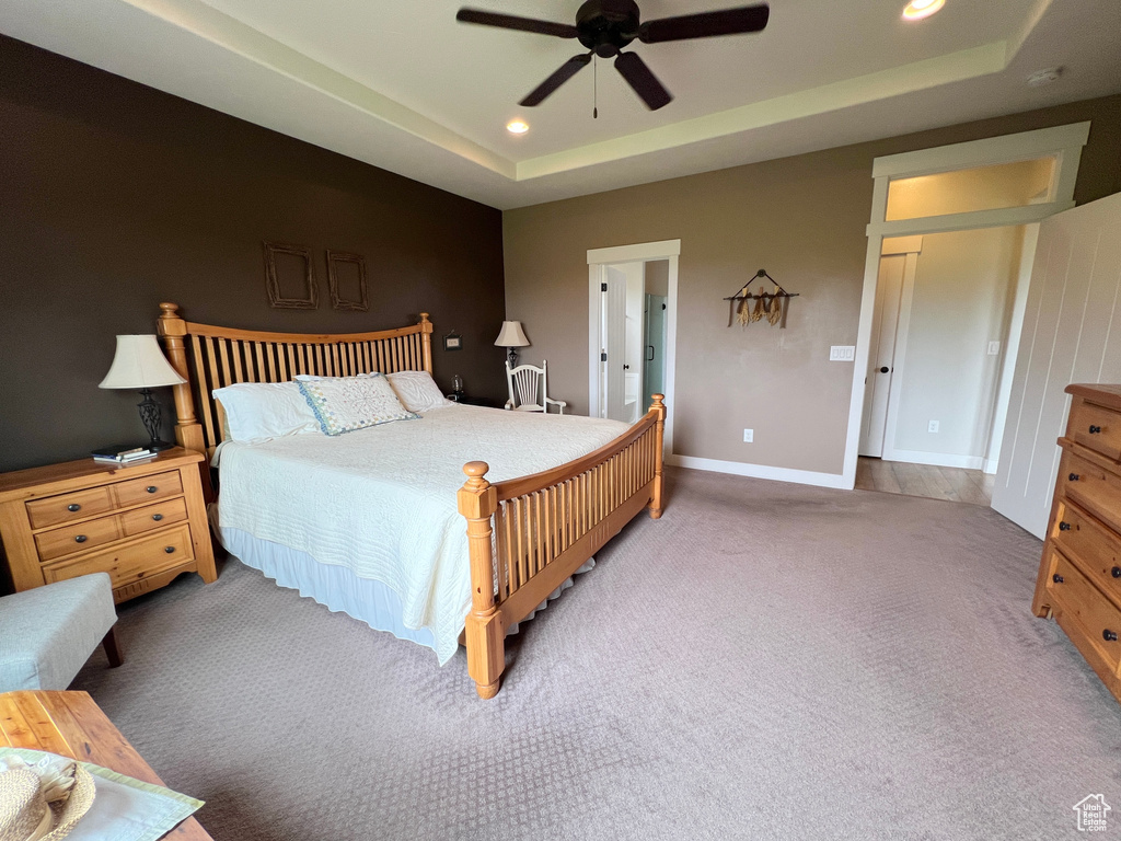 Bedroom featuring carpet floors, a tray ceiling, recessed lighting, baseboards, and a ceiling fan