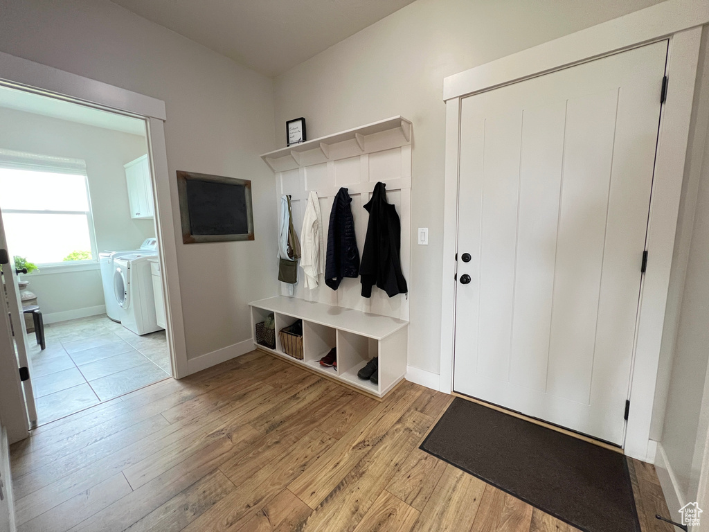 Mudroom with washer and dryer, wood finished floors, and baseboards