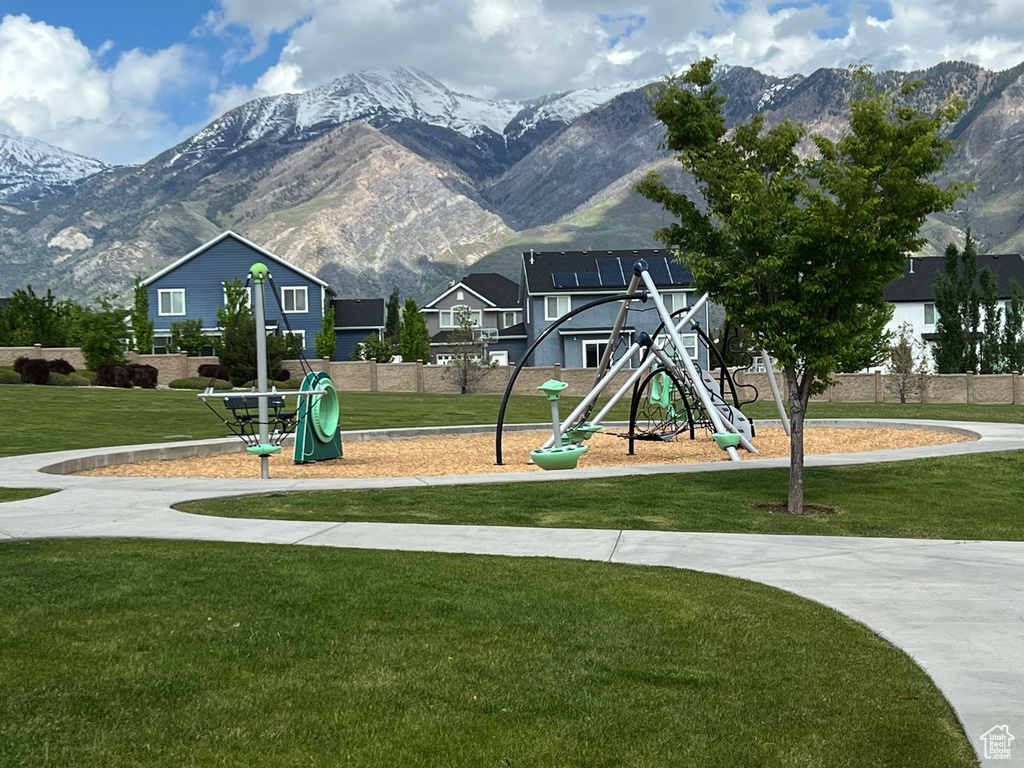 Community playground featuring a mountain view and a lawn