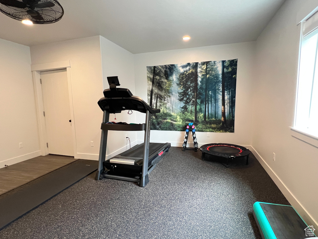 Exercise area featuring baseboards and ceiling fan