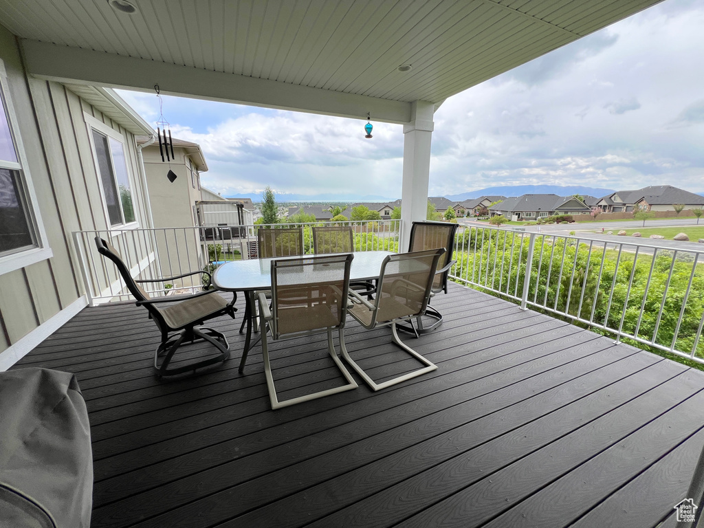 Wooden deck featuring a residential view and outdoor dining area