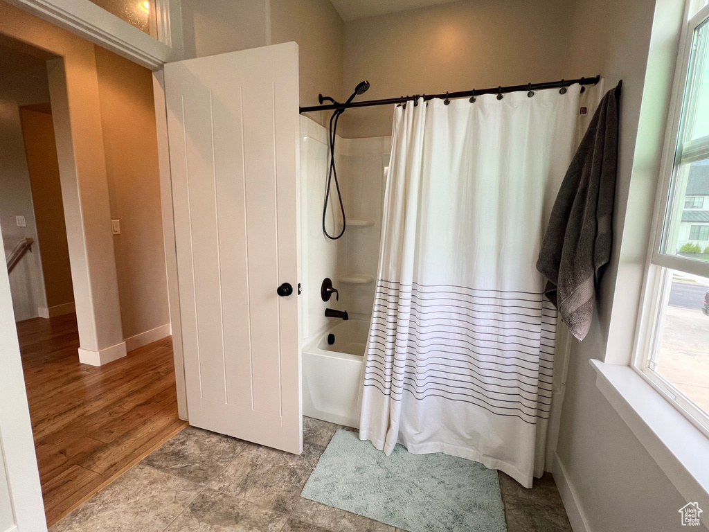Full bath with shower / bath combination with curtain and baseboards