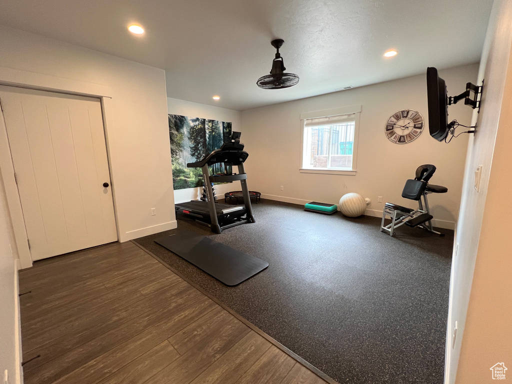 Exercise room featuring recessed lighting, dark wood-style flooring, and baseboards