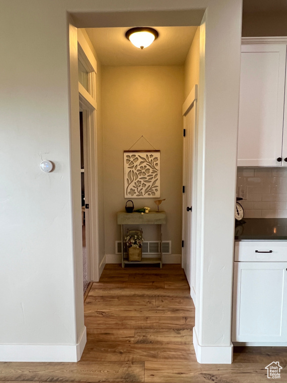 Corridor featuring light wood-type flooring and baseboards