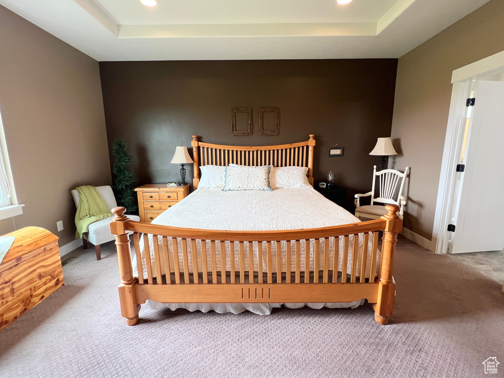 Bedroom with a raised ceiling, carpet, recessed lighting, and baseboards