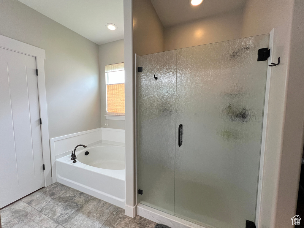 Bathroom with a stall shower, a bath, and recessed lighting