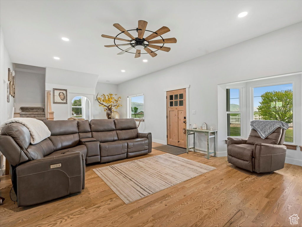 Living area featuring a ceiling fan, light wood-style flooring, recessed lighting, stairs, and baseboards