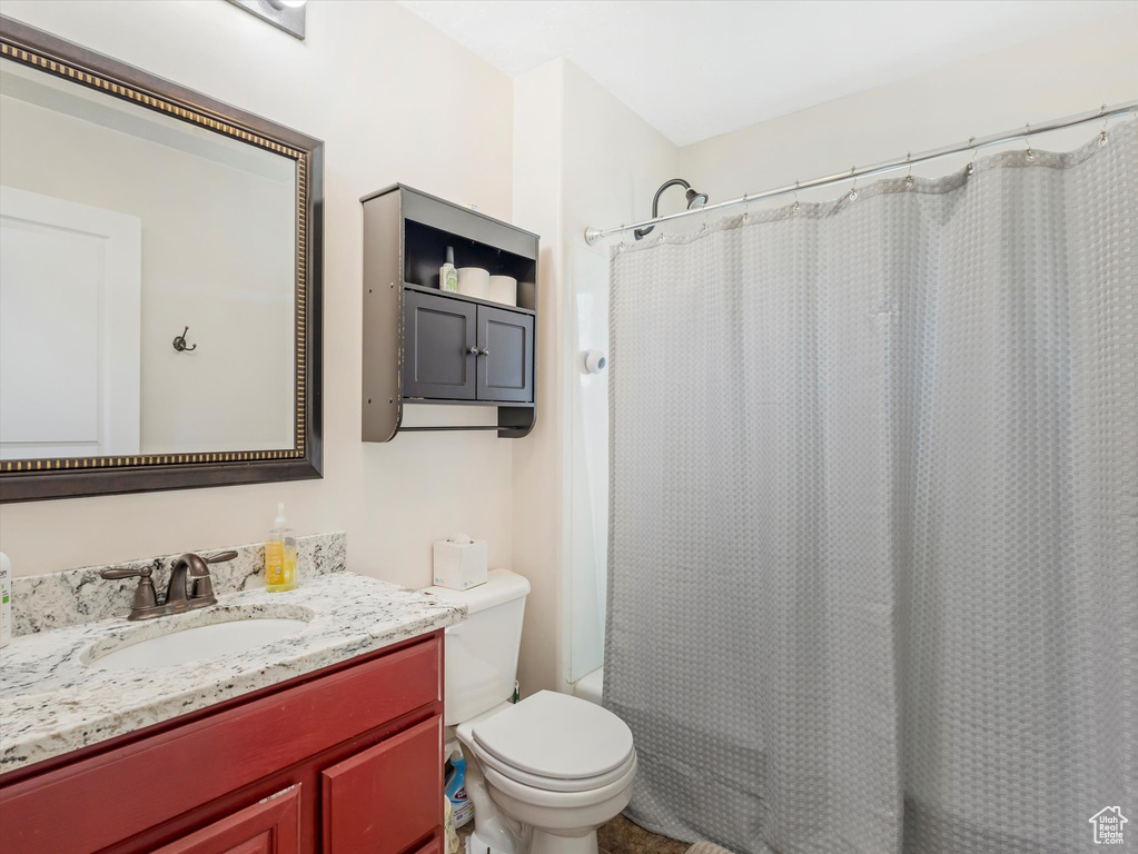 Full bathroom featuring vanity, toilet, and shower / bathtub combination with curtain