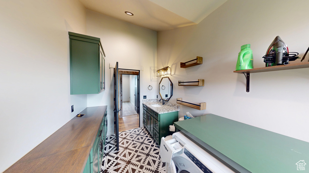 Bathroom with vanity, wood finished floors, and washer and clothes dryer