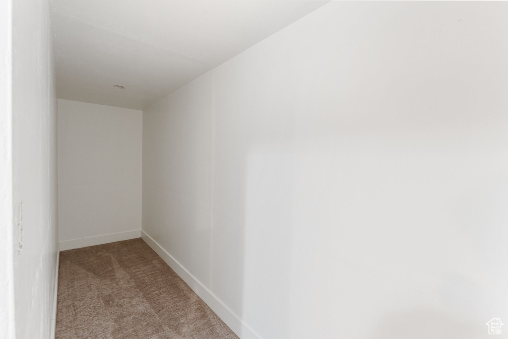 Spare room featuring carpet floors and baseboards