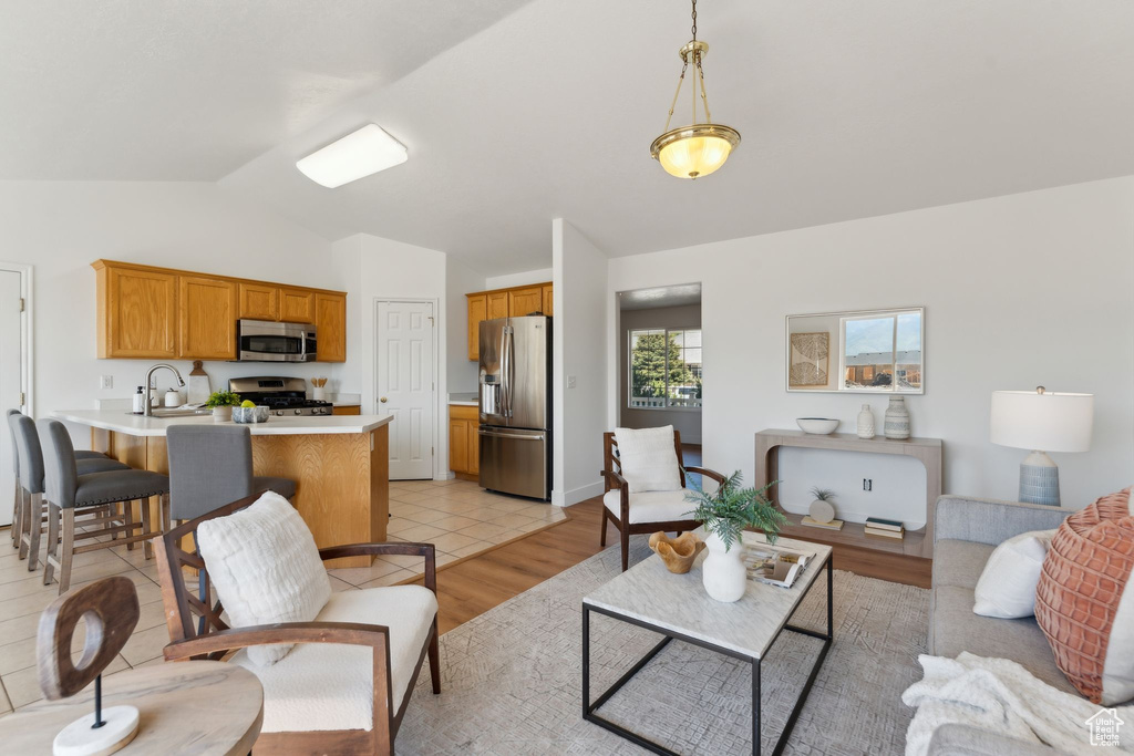 Living room featuring vaulted ceiling and light wood-style floors