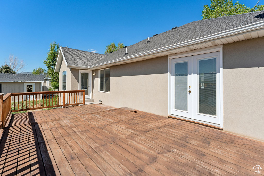 Wooden terrace with an outdoor structure and french doors