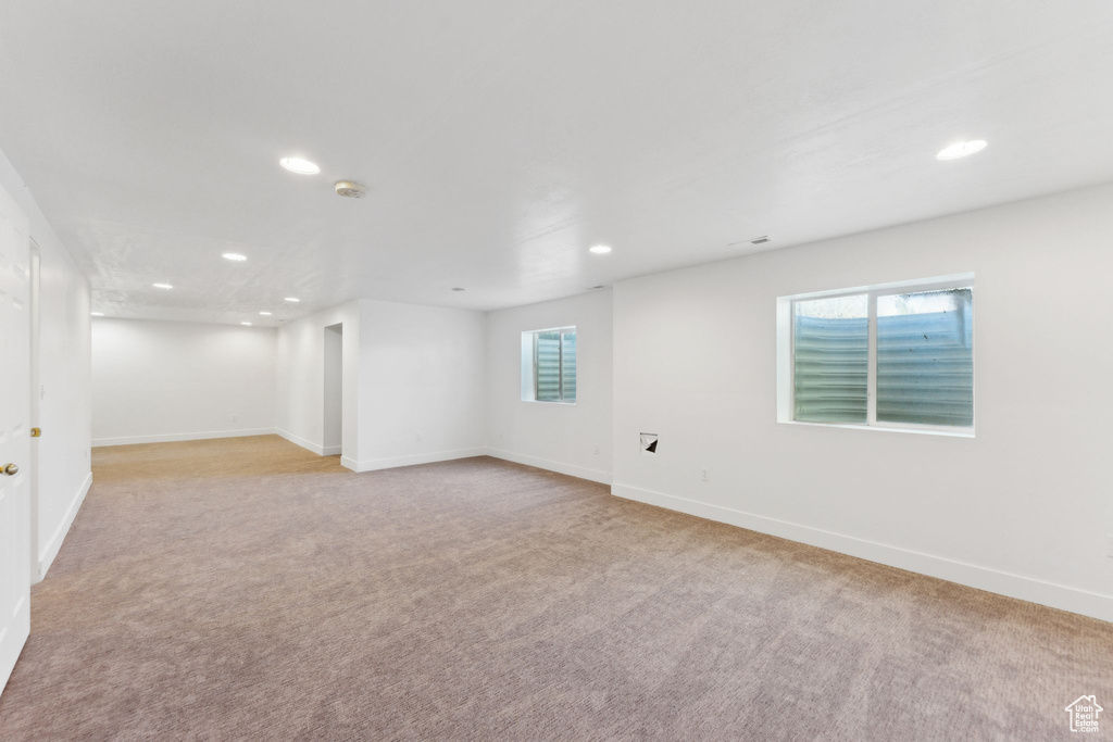 Below grade area featuring recessed lighting, light colored carpet, and baseboards