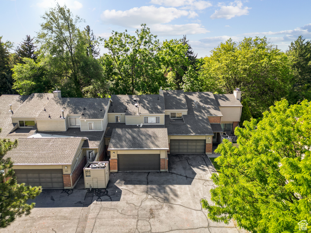 Aerial view of property and surrounding area featuring a tree filled landscape