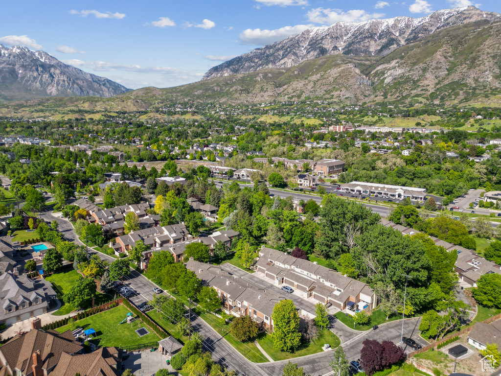 Aerial view of property and surrounding area with a mountainous background and nearby suburban area