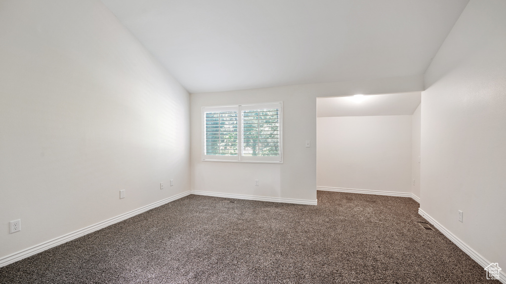 Spare room with dark colored carpet and baseboards