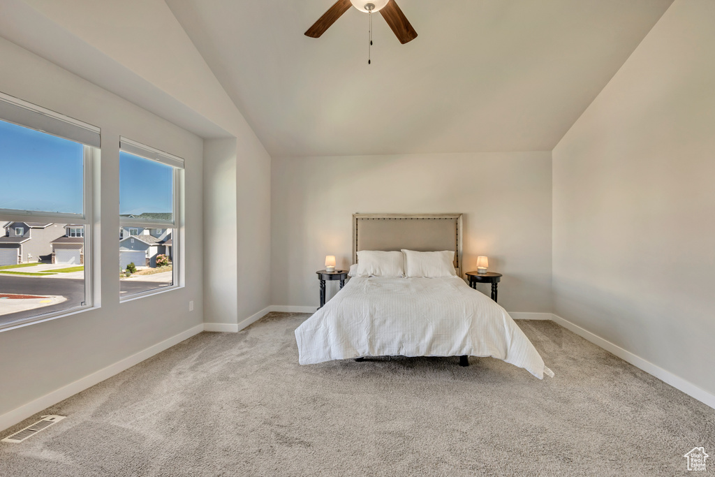Bedroom with vaulted ceiling, carpet, a ceiling fan, and baseboards