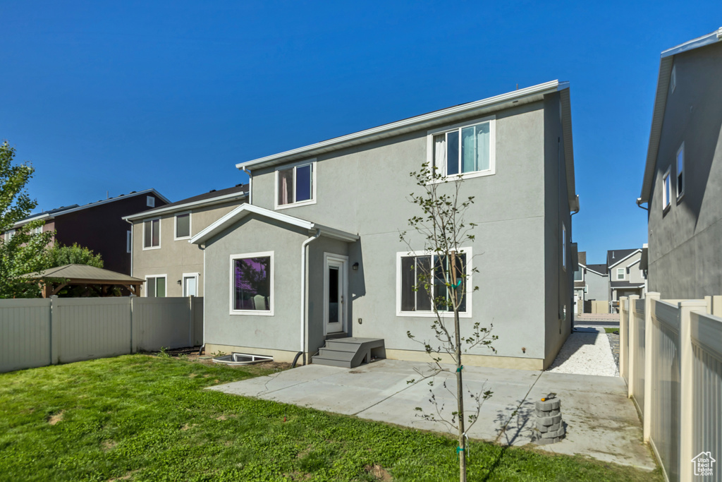 Back of property with stucco siding and a patio