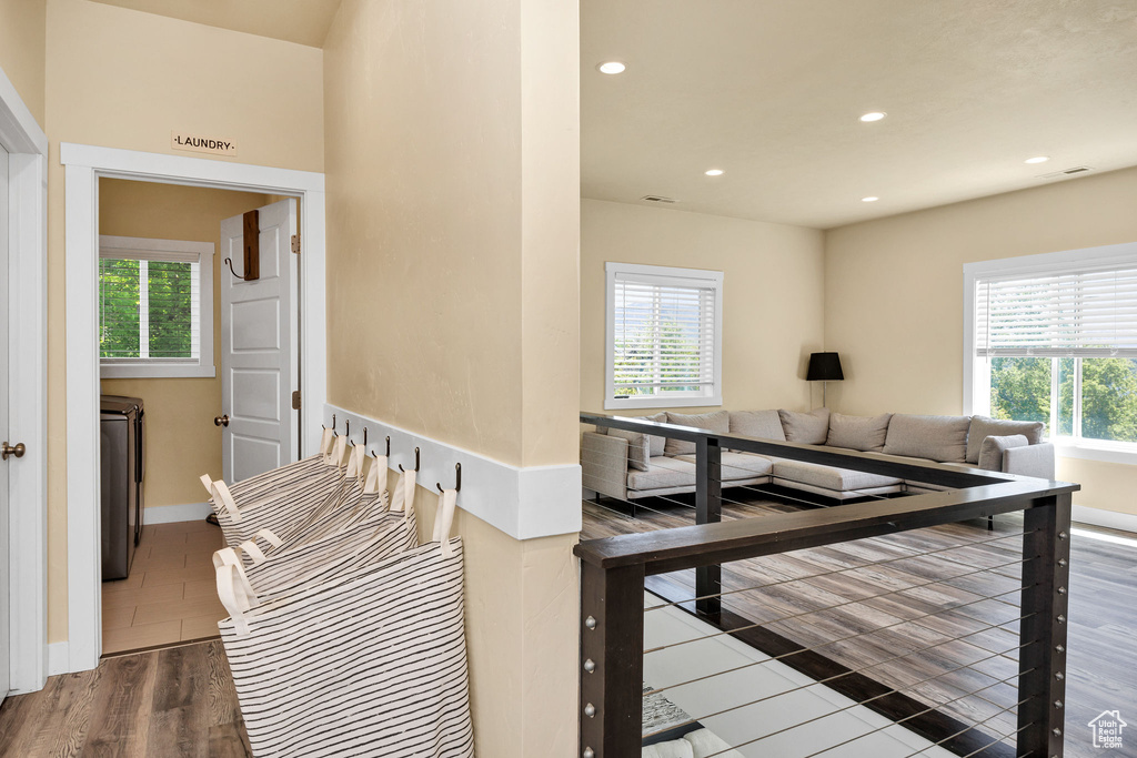 Hallway featuring plenty of natural light, recessed lighting, baseboards, and wood finished floors