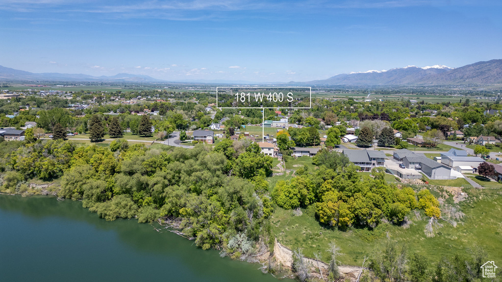 Aerial overview of property\'s location featuring a tree filled landscape and a water and mountain view