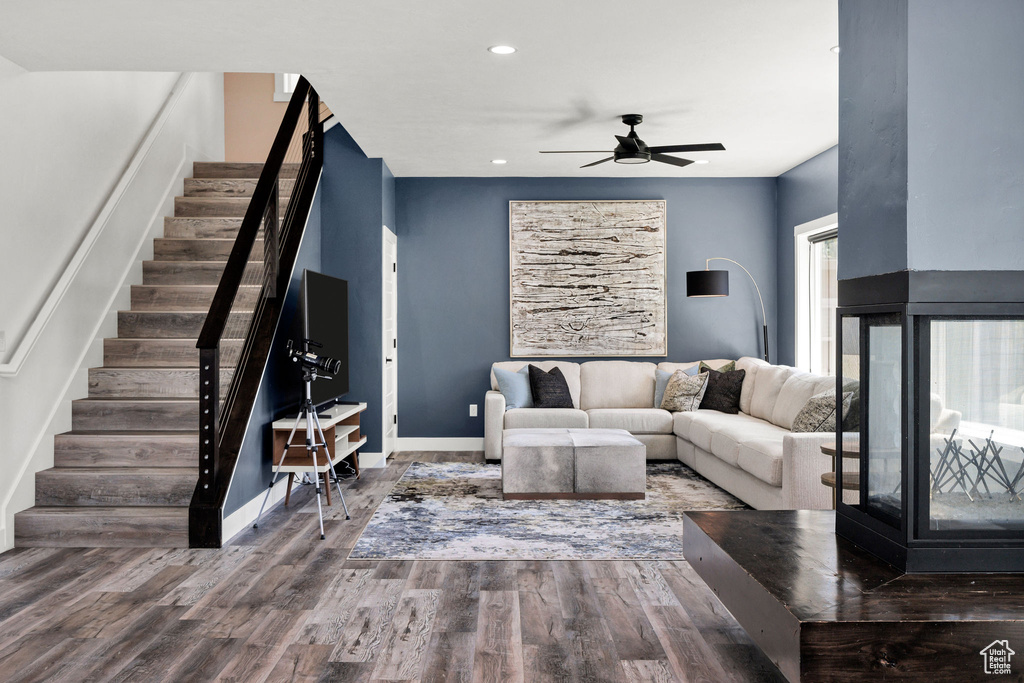 Living area with stairs, wood finished floors, ceiling fan, recessed lighting, and baseboards