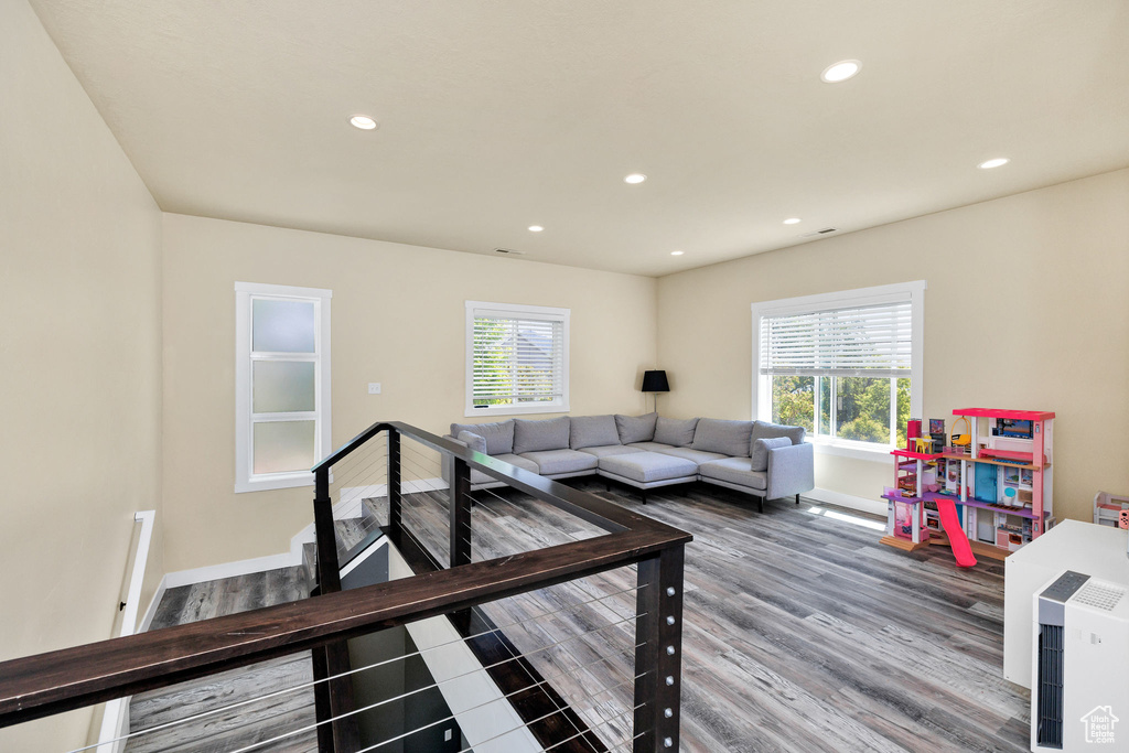 Living area with healthy amount of natural light, recessed lighting, wood finished floors, and baseboards