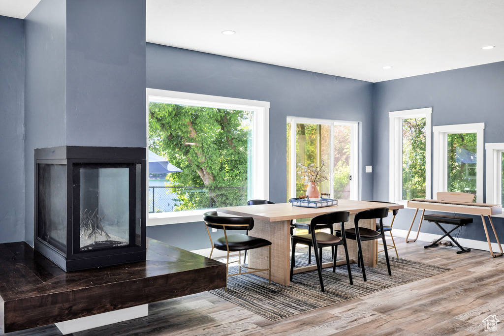 Dining room with healthy amount of natural light, wood finished floors, baseboards, and recessed lighting