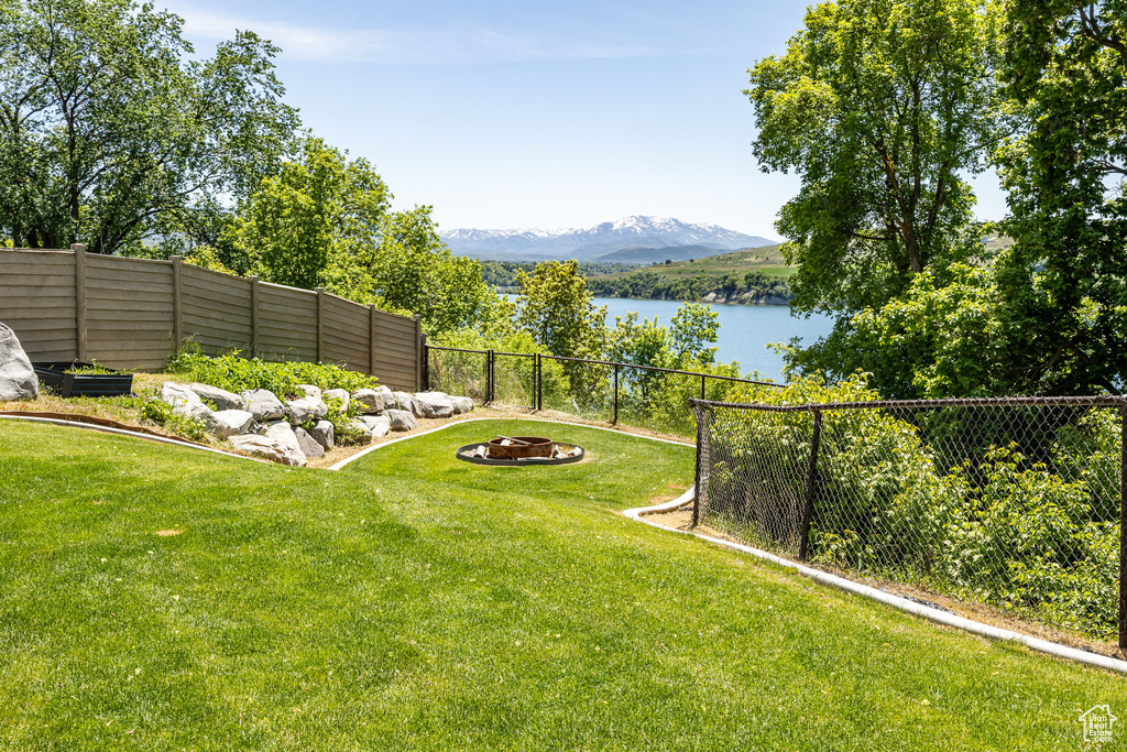 View of yard featuring a water and mountain view and a fire pit