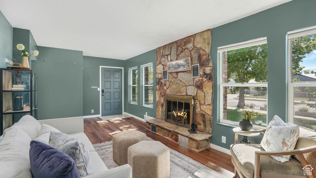 Living area featuring wood finished floors, a fireplace, and baseboards